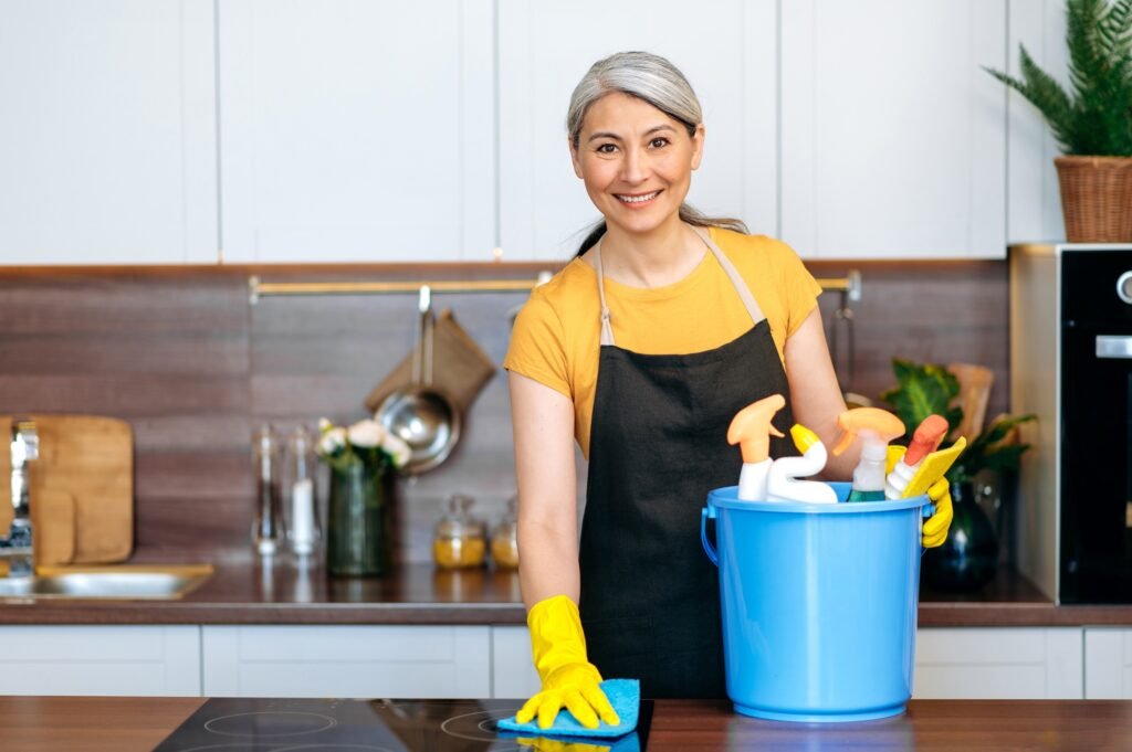 a woman wearing gloves and cleaning supplies