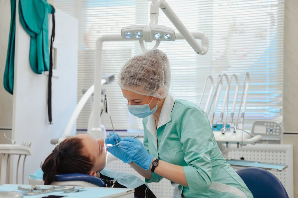 a woman in a medical mask and gloves examining a patient