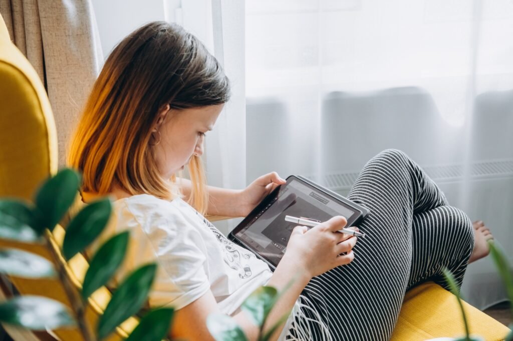 a woman sitting on a couch using a tablet