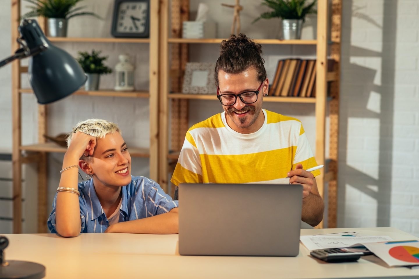 a man and woman looking at a laptop