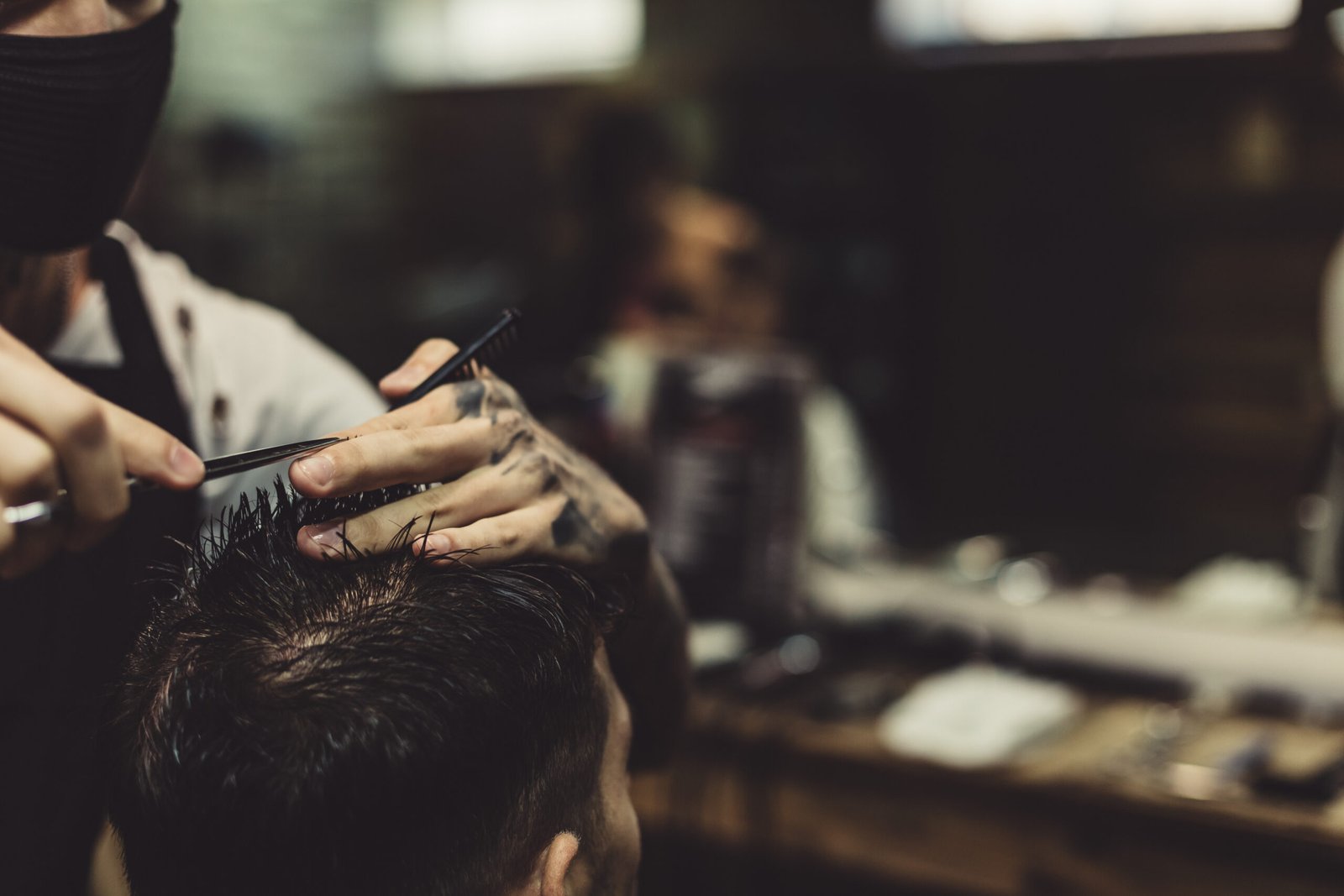 Barbero realizando un corte de pelo a un cliente, ideal para una web de barbería en Mataró